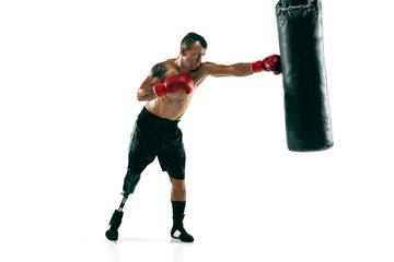 Full length portrait of muscular sportsman with prosthetic leg, copy space. Male boxer in red gloves training and practicing. Isolated on white studio background. Concept of sport, healthy lifestyle.
