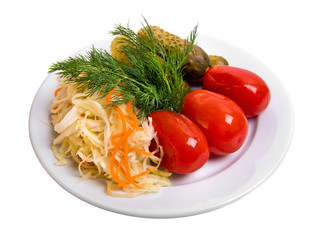 Pickled tomatoes and cucumbers, sauerkraut are on the plate, marinade assortment isolated on white.