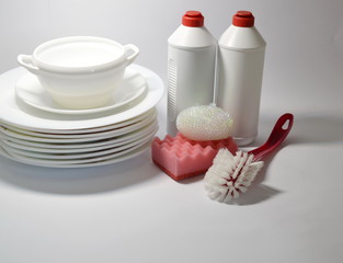  On a white background plates, dishwashing liquid, washcloths, brush.