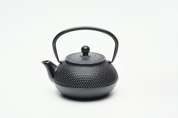 Black cast iron teapot on a white background.