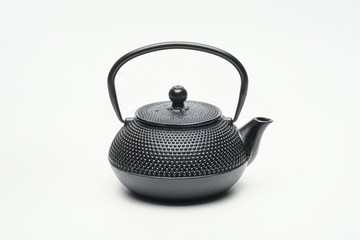 Black cast iron teapot on a white background.
