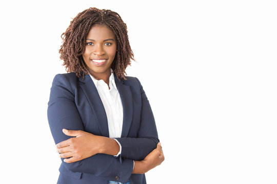 Happy successful female consultant looking at camera. Young African American business woman with arms crossed standing isolated over white background, smiling. Corporate portrait concept