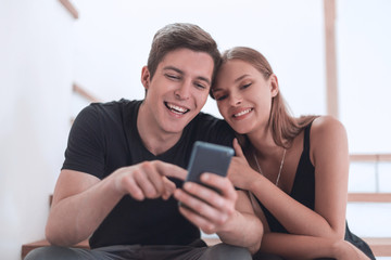 loving young couple sitting on the steps in their apartment