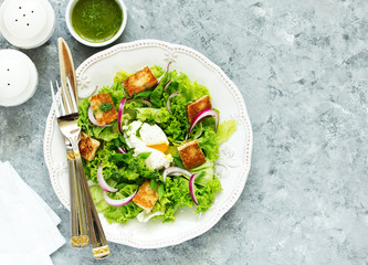 Spring salad with poached egg and crispy croutons. View from above.