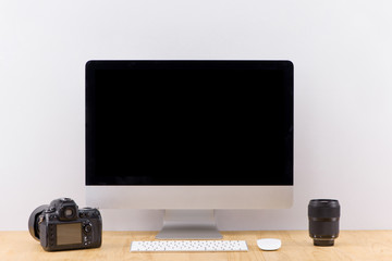 Stylish home office with blank screen desktop computer and tablet with stationery