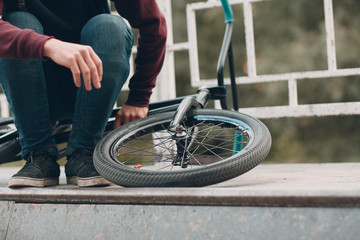 Naklejka premium Professional young sportsman cyclist with bmx bike at skatepark