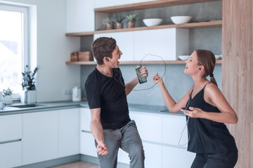 happy young couple listening to their favorite music in the kitchen