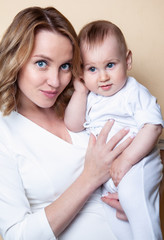 family, child and parenthood concept - happy smiling young mother with little baby at home