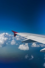Obraz premium wing of airplane flying above clouds