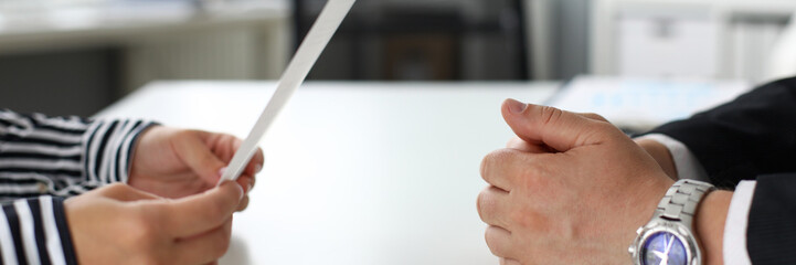 Fototapeta premium Male and female hands lying on opposite side of table communicating closeup