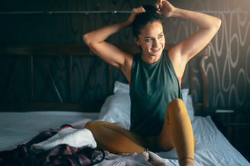 Young woman in bedroom preparing herself for training