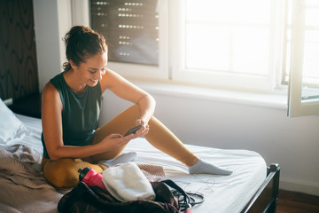 Young woman in bedroom preparing herself for training