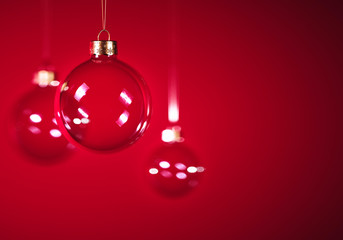 Glass christmas balls hanging in front of dark grey background