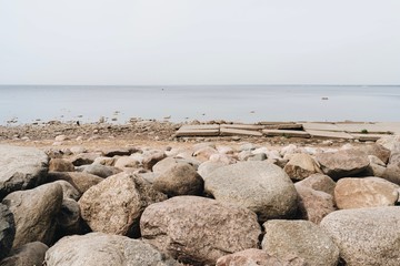 stones on the beach. Seaside. Rocks and sand on the beach. Northern landscape. The sea and the horizon.