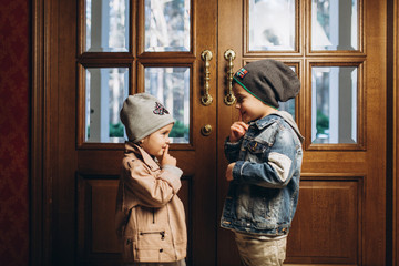 Kids playing together near window, smiling and having fun in winter time