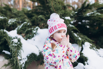 Little cute pretty girl in winter snowy park playing outdoors. Happines, joy, childhood, winetr, chistmas concept