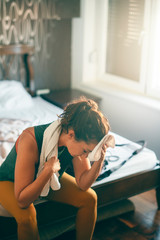 Young woman in bedroom relaxing after training