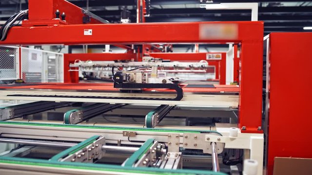 Industrial robot working at solar pannels production factory,Conveyor Tracking Controler of robotic hand. Green energy concept.