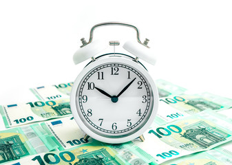 Old alarm clock watch with euro banknotes money, isolated on white background. Time and business...