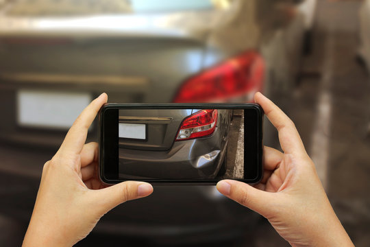 Close up hand holding smartphone and take photo at The scene of a car crash and accident, car accident for car insuranc claim