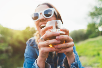 Woman with glass of beer in the field