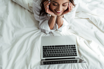 high angle view of smiling woman looking at laptop at morning