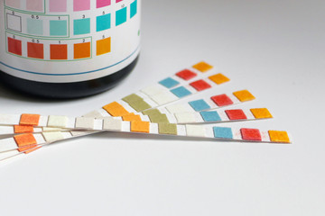 Water purity test paper strips with plastic bottle on white background © Tatiana