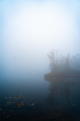Fototapeta na wymiar Pond covered in fog during autumn morning