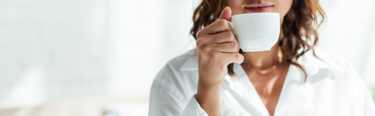panoramic shot of woman holding cup of coffee at morning