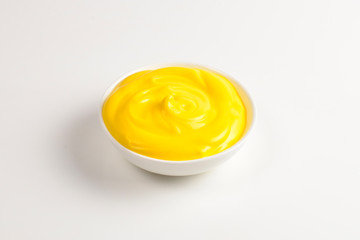 Cheese sauce in white plate on white background.