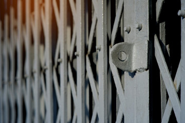 Side view and close up hasp of the old steel folding door with flare light and blurred background, house security concept