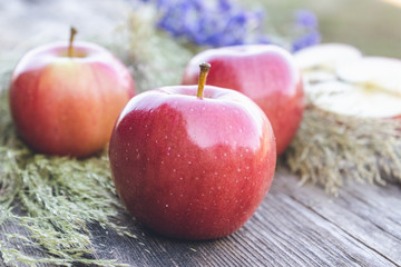 Fresh ripe red apples lie on a wooden table. Vitamins and a healthy diet. Vegetarian concept.