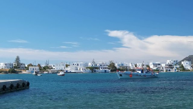 Fisherman boat arrive at pier in Milos island, Greece on sunny day