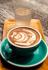 Hot mocha coffee with latte art and glass of water