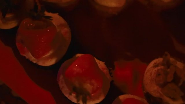 overhead shot of cupcakes dolly move left with a red light