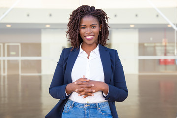 Happy successful consultant posing near office building. Young African American business woman with...