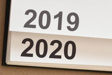 New Year 2020 coming concept. Notebook pages with the text 2019 and 2020.