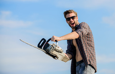 Lumberjack with chainsaw in his hands. Masculinity concept. Sharp blade. Dangerous job. Feeling...