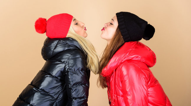 Winter kiss. Best friends matching outfits. Soulmates girls kiss. Women wear down jackets. Girls makeup face wear winter jackets. Fashion trend. Winter season. Glad to see you. Best friends forever
