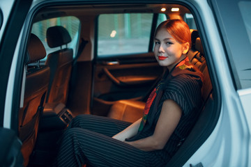 Fototapeta na wymiar Young woman sitting in back seat of car vehicle with opened door. Taxi concept.