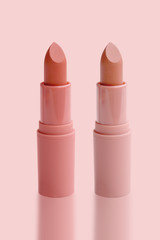 set of matte lipstick on a delicate pink background, red, raspberry, pink, coral, peach color, close-up, the concept of decorative cosmetics
