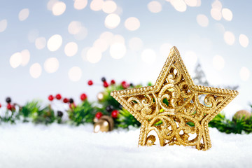 Fototapeta na wymiar Christmas gold star on snow with decoration.