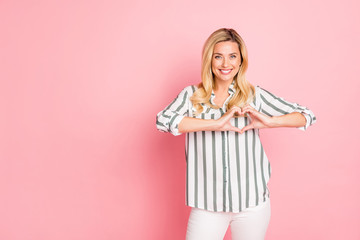 Photo of cheerful positive cute pretty nice woman smiling toothily showing you heart sign shaped...