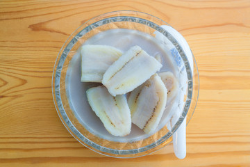 Banana in the coconut milk Kluay Buad Shee wood background