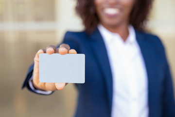 Businesswoman showing credit card. Young African American business woman holding blank card,...