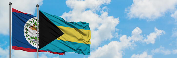 Belize and Bahamas flag waving in the wind against white cloudy blue sky together. Diplomacy concept, international relations.