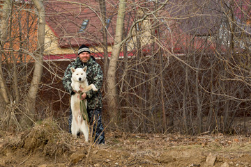 A man in overalls for a walk with a dog