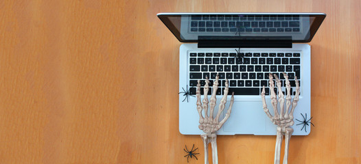 Skeleton hands typing on laptop