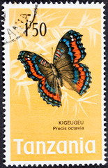Fototapeta na wymiar Stamp from Tanzania with a photo of a beautiful single colored butterfly on paper