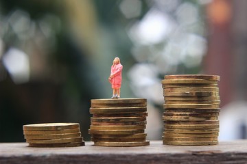Conceptual Close Up Photo, successful businesswoman stand at golden rupiah coin money